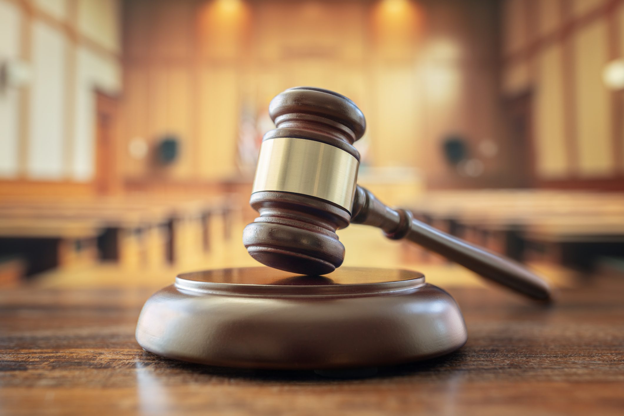 Gavel on wooden table in courtroom.