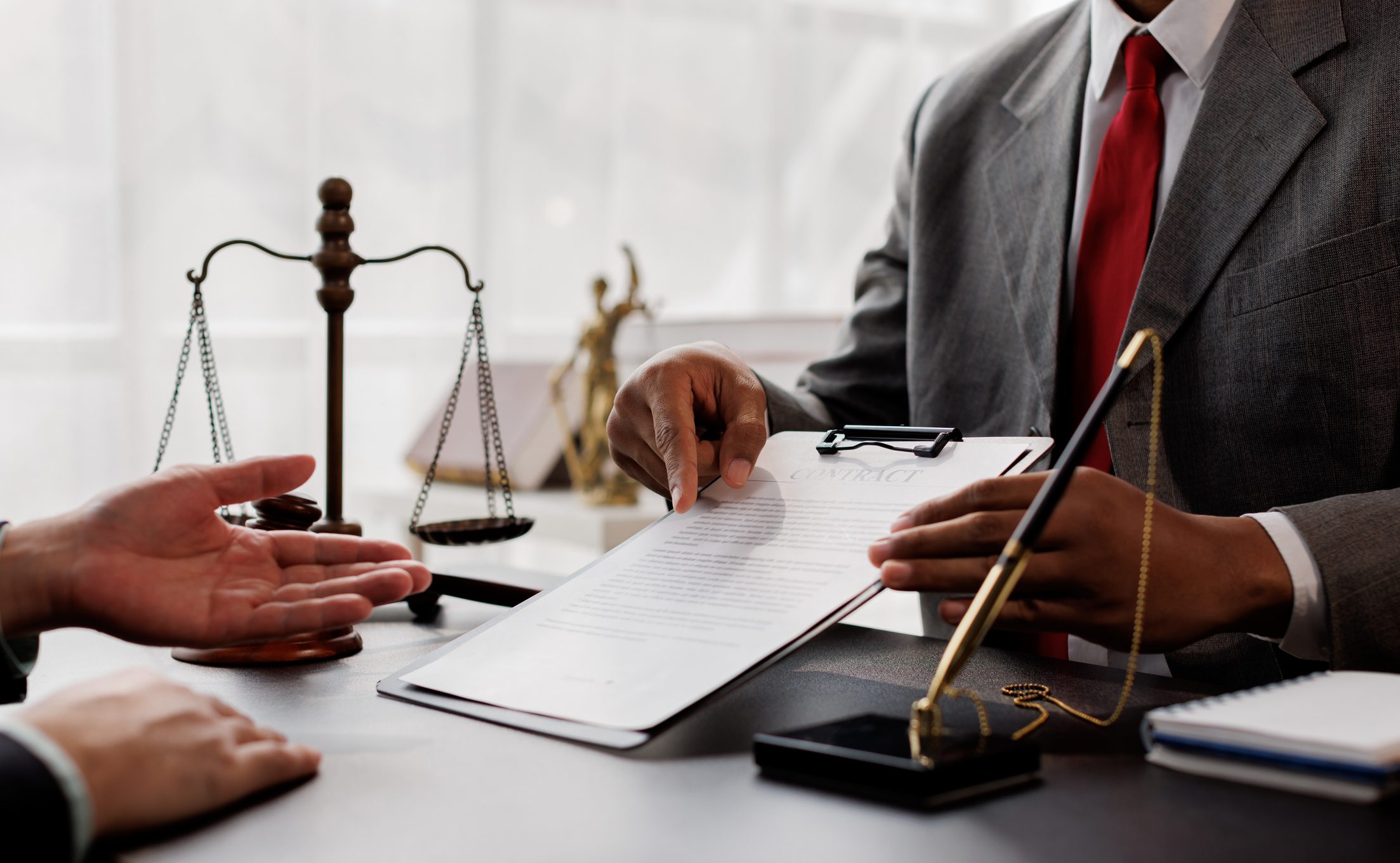 Lawyer discussing document with client in office.