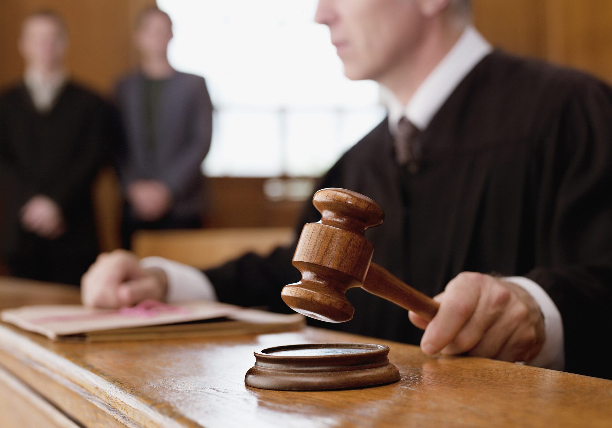 Judge holding gavel in a courtroom.