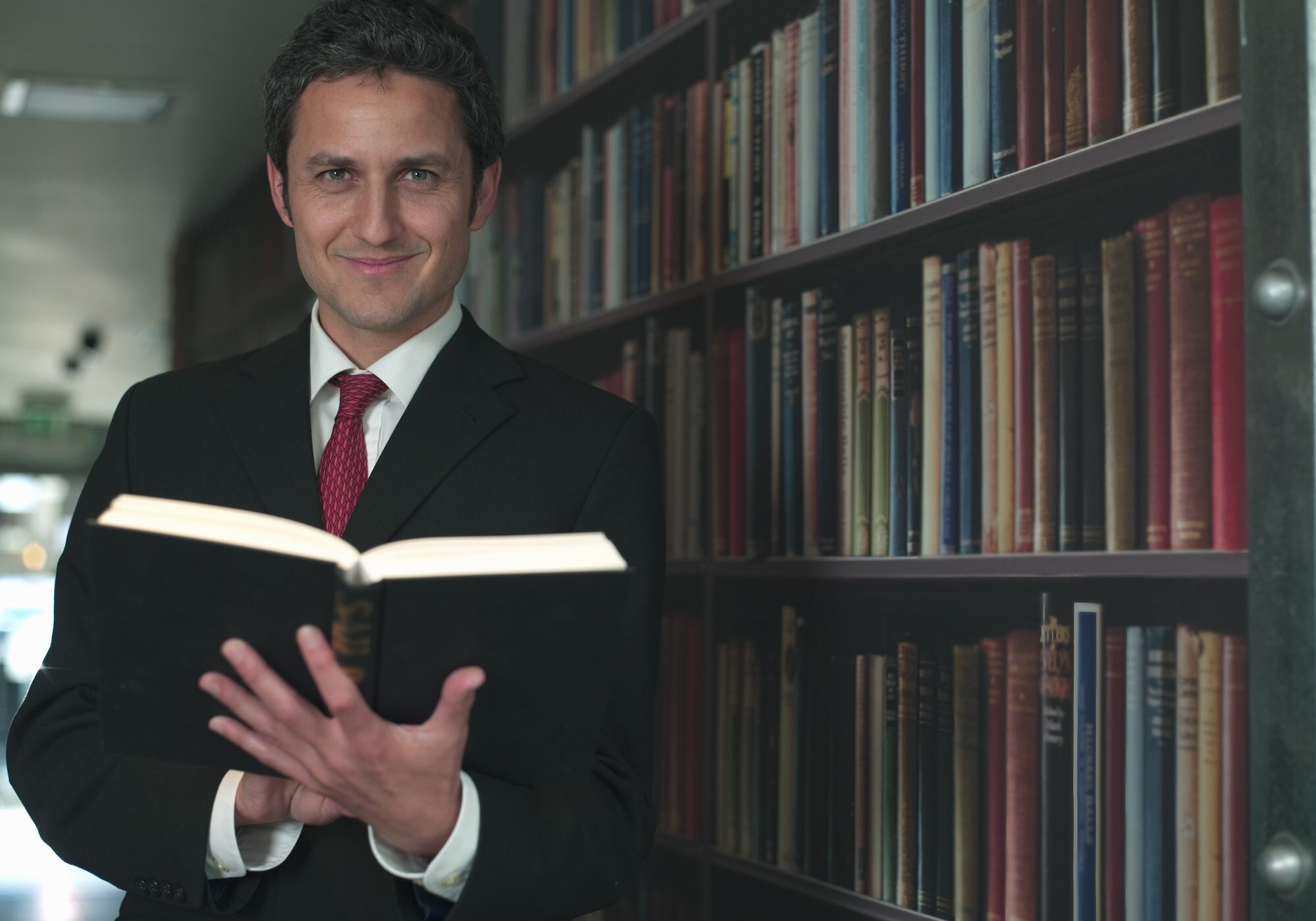 Man reading a book in library.
