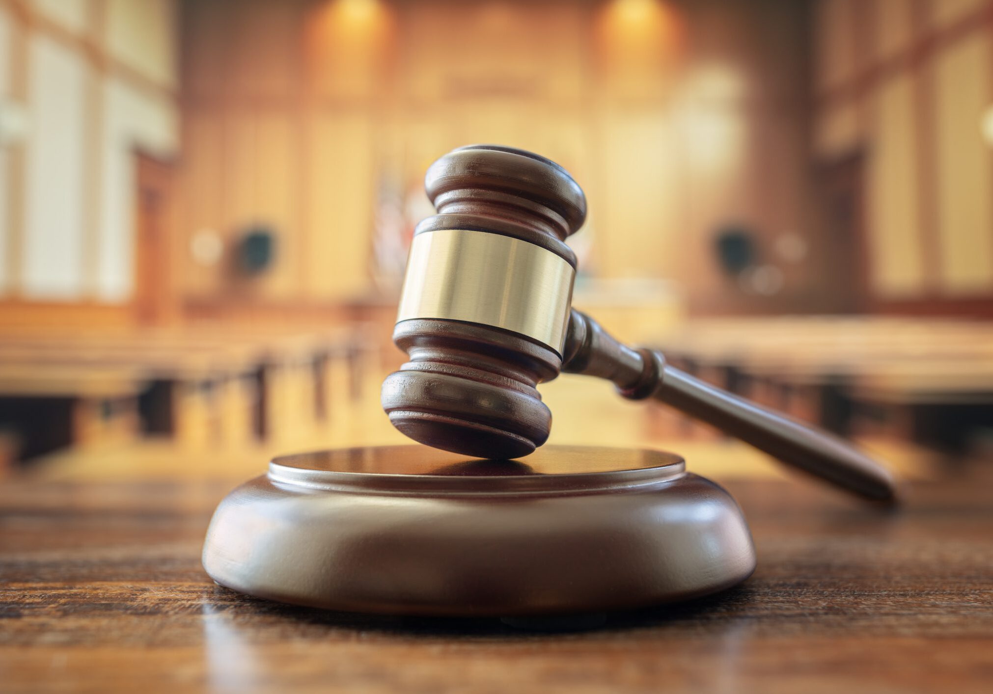 Gavel on wooden table in courtroom.