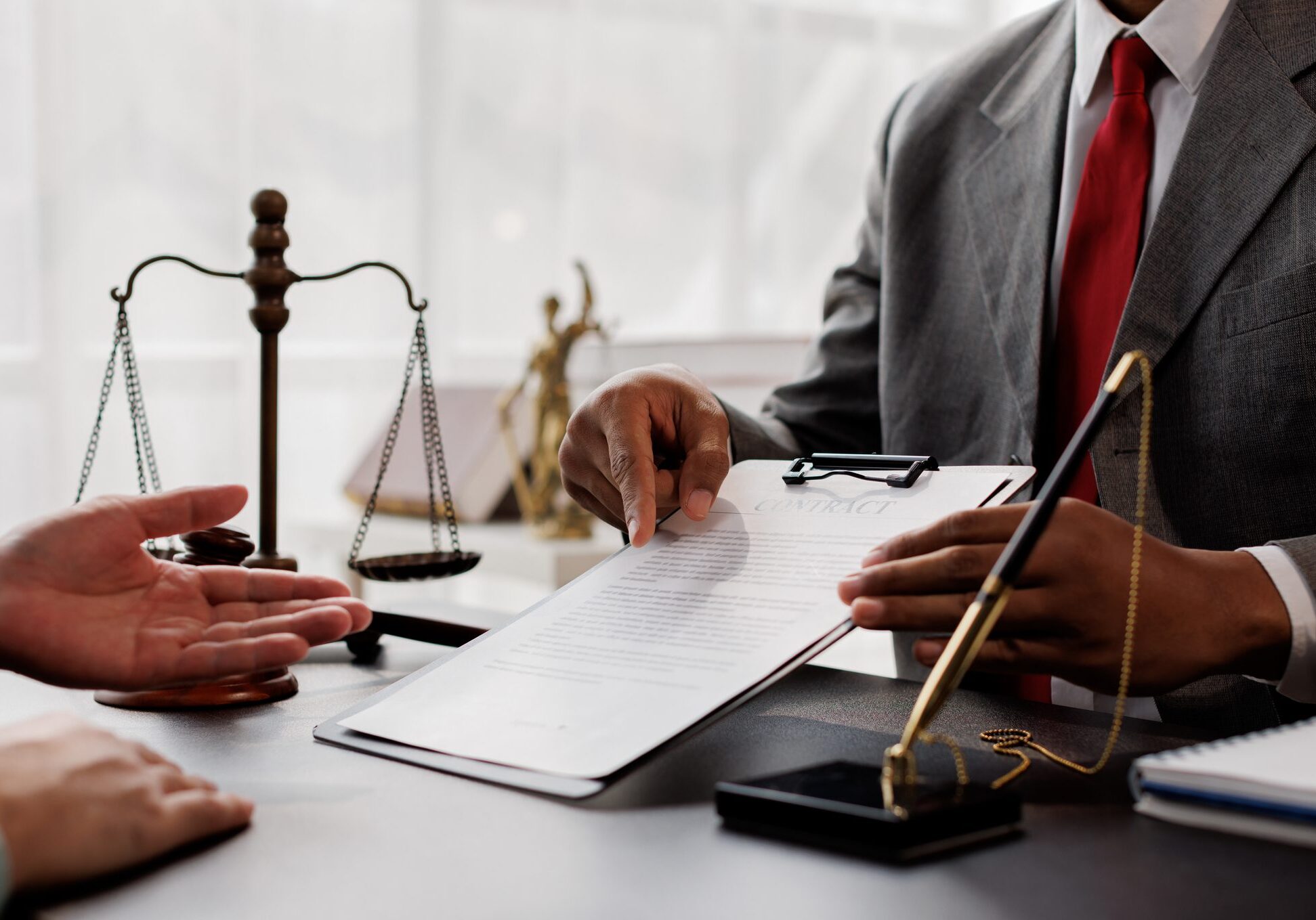 Lawyer discussing document with client in office.